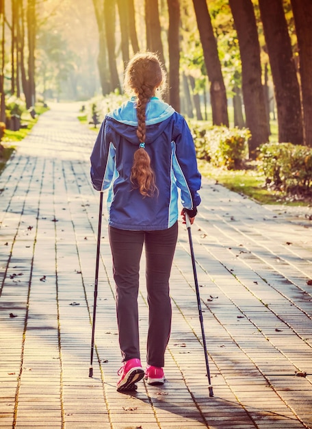 aventura de caminhada nórdica e conceito de exercício mulher caminhando com postes de caminhada Nórdica no parque