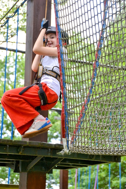 aventura de escalada de alambre alto parque de la gente en el curso en casco de montaña