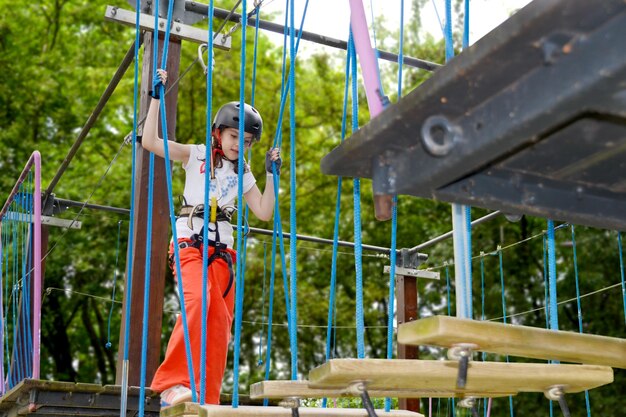 aventura de escalada de alambre alto parque de la gente en el curso en casco de montaña