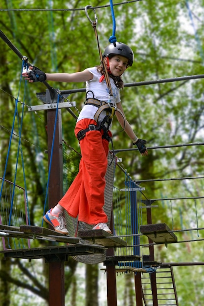 aventura de escalada de alambre alto parque de la gente en el curso en casco de montaña