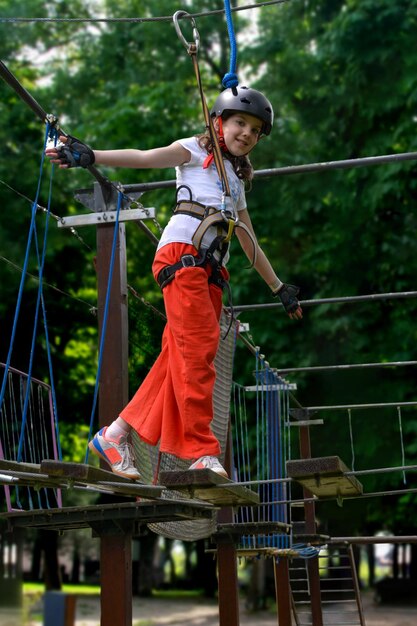 Foto aventura de escalada de alambre alto parque de la gente en el curso en casco de montaña