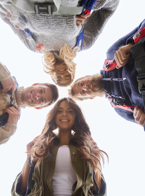 Foto aventura, viagens, turismo, caminhada e conceito de pessoas - grupo de amigos sorridentes com mochilas em círculo ao ar livre