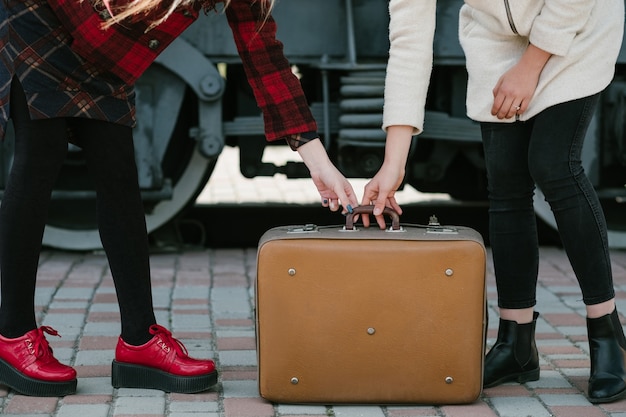 Aventuras de viaje. confusión de equipaje. viaje vacaciones vacaciones. dos mujeres sosteniendo la misma maleta.