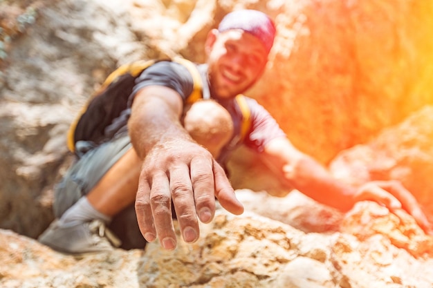 Aventureros ayudándose unos a otros a escalar la montaña.