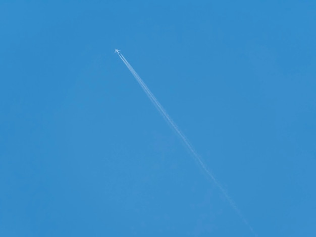 Avião com rastro de vapor contra um céu azul