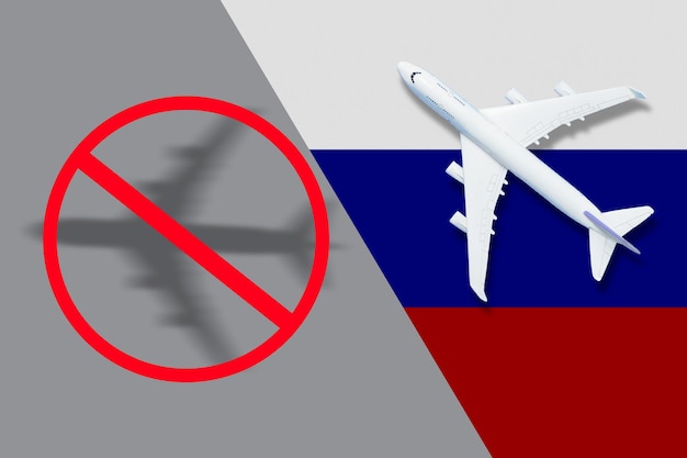 Avião de brinquedo de bandeira russa e arame farpado no conceito de fundo de proibição de aeronaves que partem da Rússia