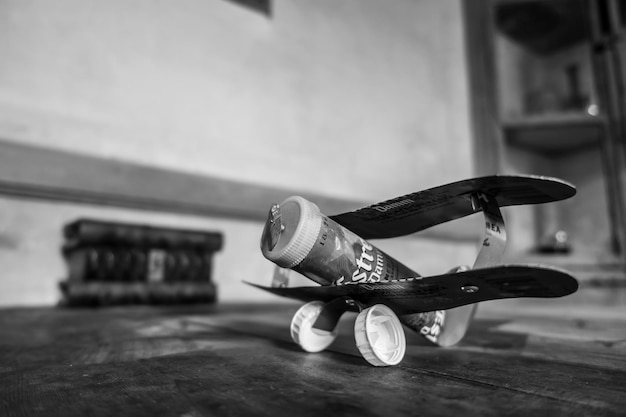 Foto avião de brinquedo feito de tampão de garrafa e recipiente na mesa