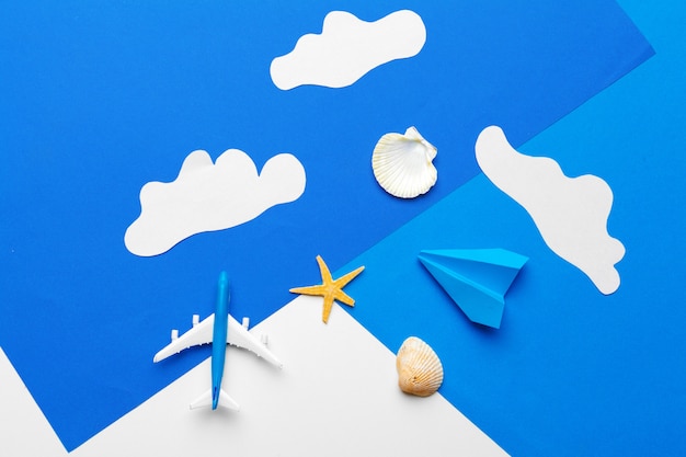 Avião de papel em um papel azul com nuvens