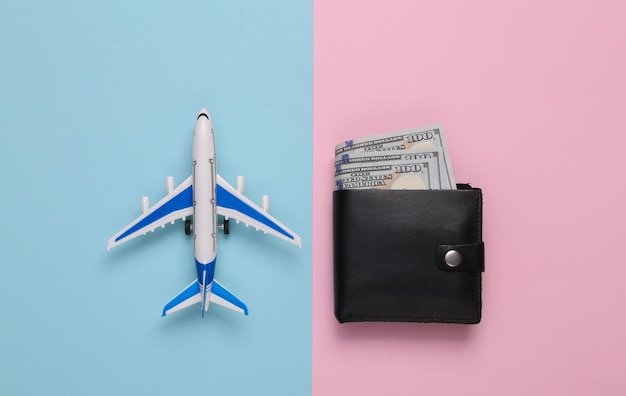 Avião de passageiros e carteira com dinheiro em fundo rosa-azul Conceito de viagem Vista superior
