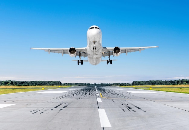 Avião de passageiros pousando em bom tempo claro com céu azul em uma pista