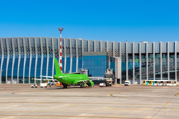 Foto avião de passageiros verde no aeroporto em dia ensolarado