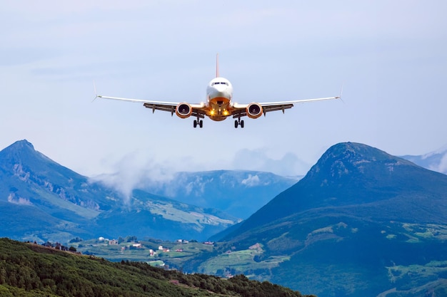 Foto avião de passageiros voa sobre as montanhas indústria de transporte aéreo