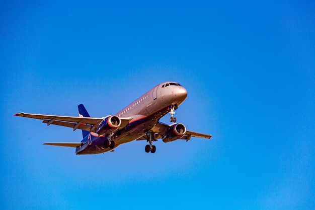 Avião de passageiros voando no céu azul em raios de luz solar