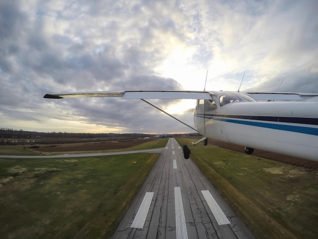 Avião decolando da pista durante um pôr do sol nublado