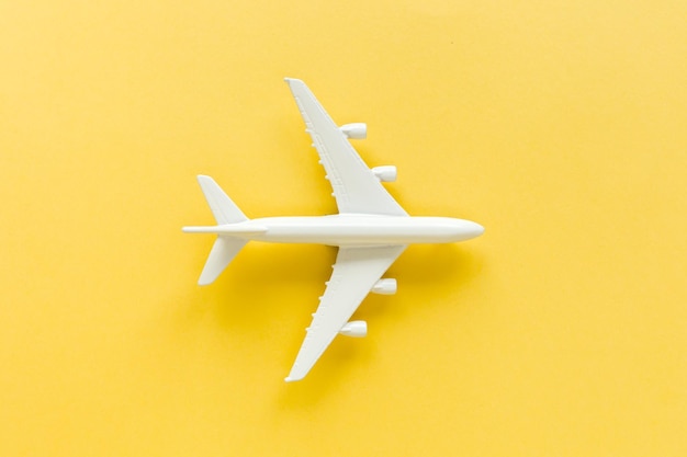 Avião modelo branco sobre fundo amarelo Vista superior plana leiga