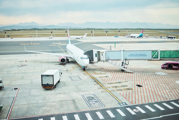 Avião na aeronave estacionária do aeroporto na pista e na pista para viagens internacionais de passageiros no horizonte do céu