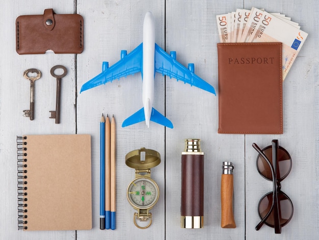 Foto avião passaporte dinheiro bússola óculos de sol binóculos bloco de notas chaves carteira