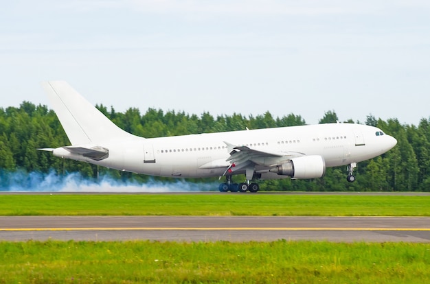 Avião pousando na pista do aeroporto com fumaça do chassi