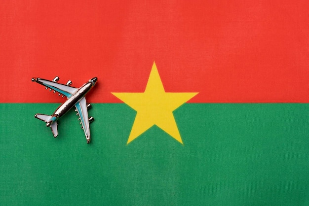 Avião sobre a bandeira de burkina faso o conceito de viagem