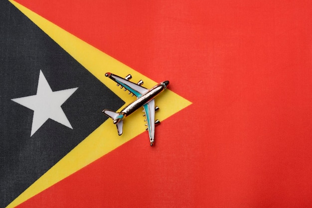 Avião sobre a bandeira de Timor-Leste o conceito de viagem