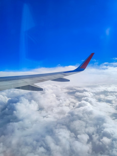 Avião voando acima das nuvens - asa de aeronave no céu azul