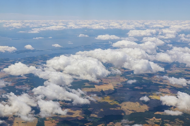 Avião voando acima das nuvens sobre a bela terra acima é o céu azul