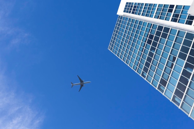 Avião voando acima de um arranha-céu