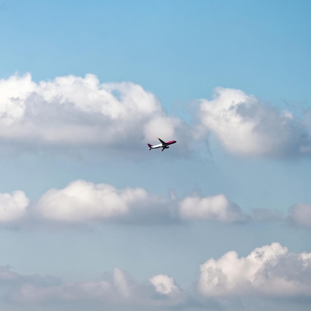 Avião voando alto no céu com nuvens brancas em Bolonha, Itália