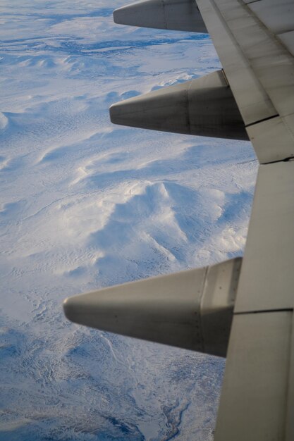 Foto avião voando sobre a neve durante o inverno