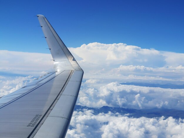 Foto avião voando sobre nuvens contra o céu azul