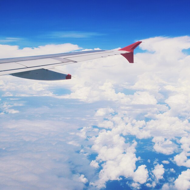 Avião voando sobre nuvens contra o céu azul