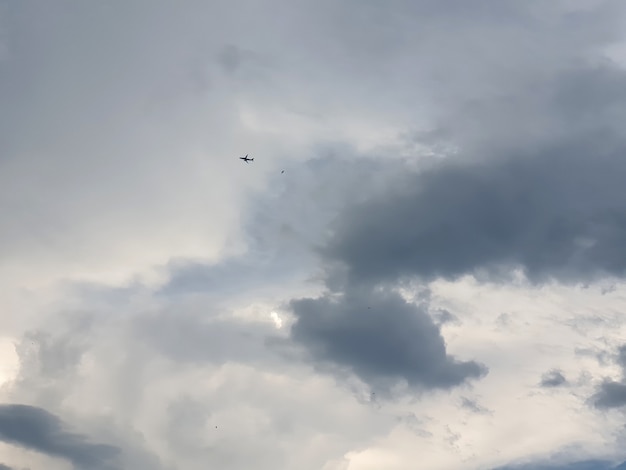 Avião voando sobre nuvens nimbus no fundo do céu