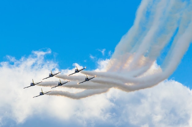 Aviões de combate a aeronaves fumam o fundo de céu azul nuvens brancas