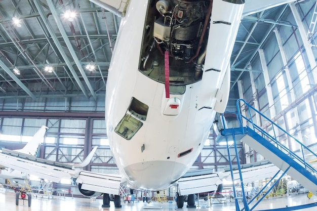 Aviões de passageiros brancos no hangar Verificando sistemas mecânicos para operações de voo