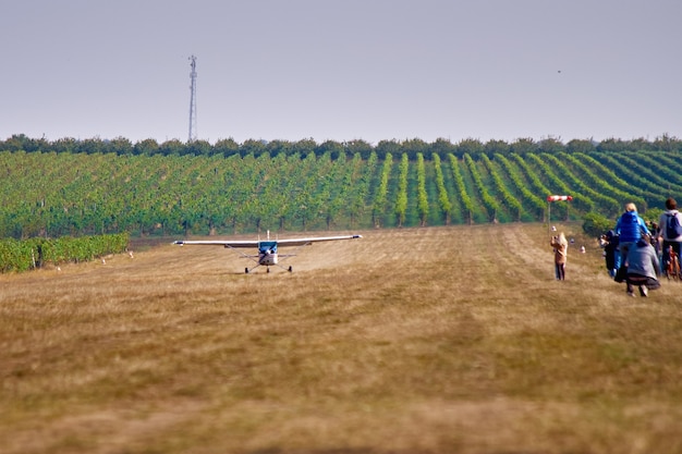 Aviões leves. Uma aeronave pousa em um campo perto de um vinhedo