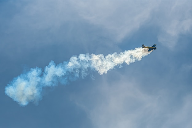 El avión acrobático con pista de humo en el cielo.