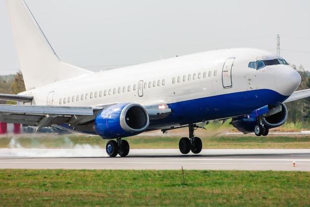 Avión aterrizando en la pista. Aterrizaje con humo de neumáticos