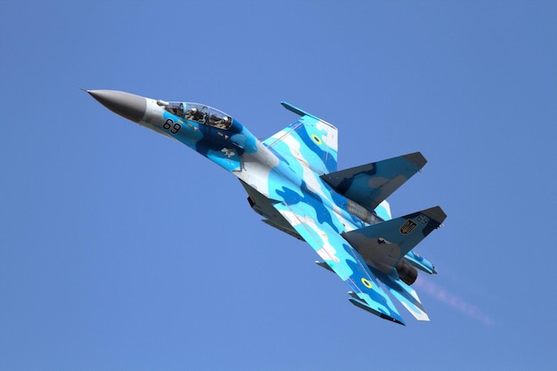 Foto un avión azul con el número 3 en la cola está volando en el cielo