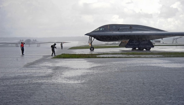 Un avión b - 52h está estacionado en una pista bajo la lluvia.