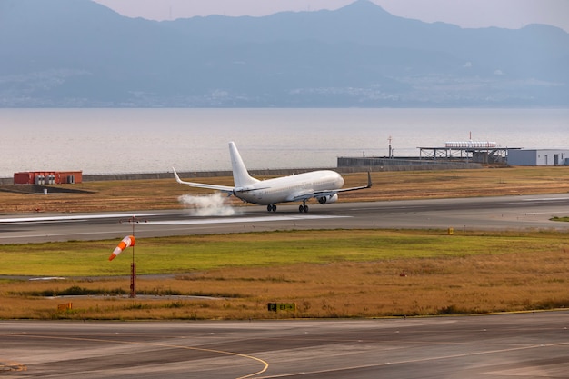 Un avión blanco aterrizando en el aeropuerto