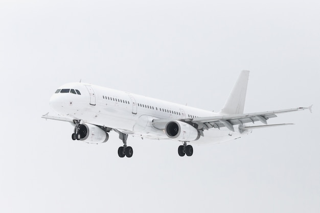 Avión blanco con chasis en el cielo preparándose para aterrizar