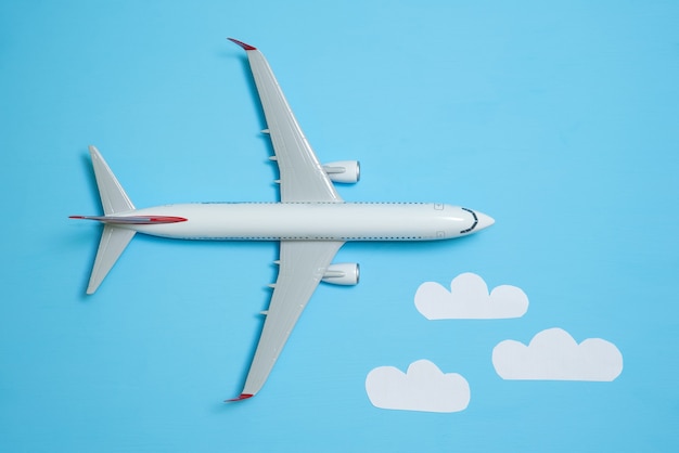 Avión blanco sobre un fondo azul con nubes