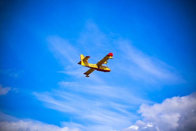 Avión de bombero amarillo brillante en un cielo azul