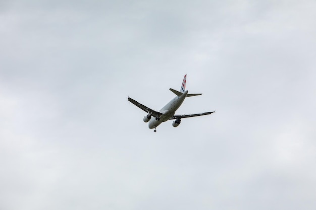 Avión en cielo aterrizando clima nublado