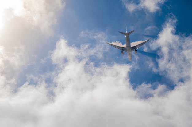 Avión en el cielo azul con nubes. Viaja por el mundo en el aire