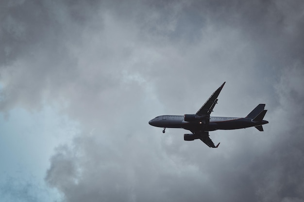 El avión en el cielo nublado vuela desde el aeropuerto después de la lluvia de verano.