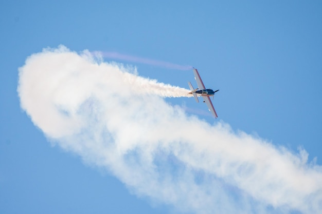 Avión de combate acrobático con humo en el cielo