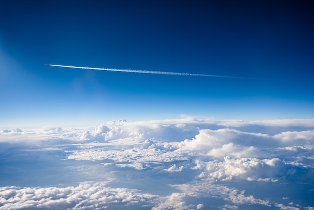 Avión comercial volando sobre las nubes en un día soleado