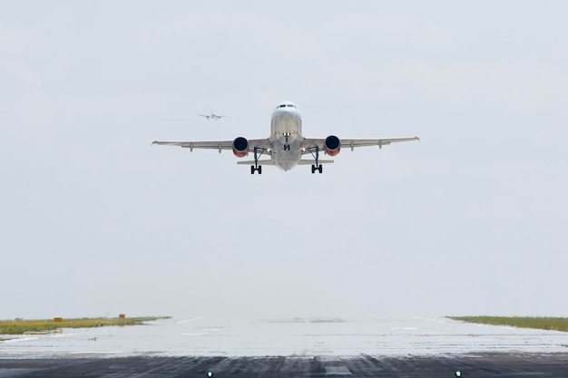 Avión despegando de la pista del aeropuerto mientras otro avión se acerca al aterrizaje