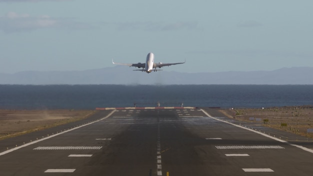 Avión despegando y volando sobre el mar.